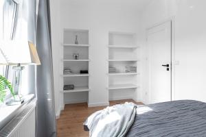 ein weißes Schlafzimmer mit einem Bett und einem Fenster in der Unterkunft Parkowa 33 Apartment Sopot in Sopot