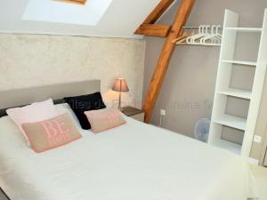 1 dormitorio con cama blanca y almohadas rosas en Gîte Bridoré, 3 pièces, 4 personnes - FR-1-381-84 en Bridoré