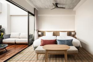 a bedroom with a bed and a table at Nest Hotel Naha Kumoji in Naha