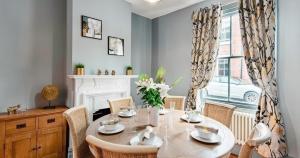 a dining room with a table and chairs and a fireplace at The Kings Place in Chester