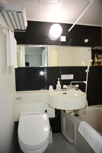 a bathroom with a sink and a toilet and a mirror at BRILLIANCE Hotel in Nagoya +10 photos
