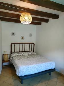 1 dormitorio con cama y lámpara de araña en Lo Raconet, en Sant Llorenç de Montgai