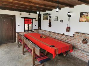 a dining room with a red table and chairs at АРНАТА КЪЩА in Yakovtsi