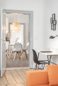 a living room with a table and chairs and a mirror at InnsbruckHomes at Botanical Garden in Innsbruck