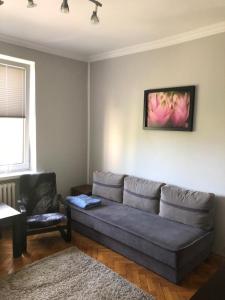 uma sala de estar com um sofá e uma cadeira em Apartament Roma Gizycko em Giżycko
