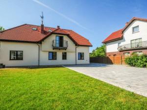 a white house with a red roof and a yard at Willa u Tośka in Kołobrzeg