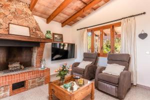 a living room with two chairs and a fireplace at Son Mulet in Llubí