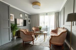 a living room with chairs and a table at Daisy's Secret Apartment in Pszczyna