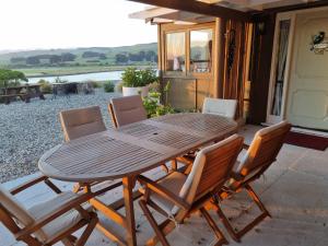 a wooden table and chairs on a patio at Catlins Lake Sanctuary in Owaka