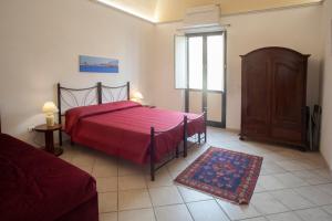 1 dormitorio con cama roja y ventana en Case Vacanze "Residenze Trapanesi", en Trapani