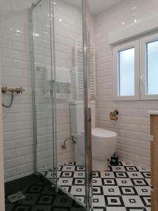 a bathroom with a toilet and a glass shower at Piso deluxe en el centro con ascensor in Castro-Urdiales