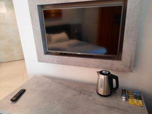 a coffee pot on a counter with a tv on a wall at Hotel Shoreline in St Julian's