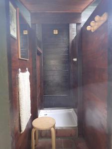 a small bathroom with a stool and a bath tub at Chalet à fleur de rêve in Maroilles +16 photos