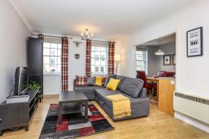 - un salon avec un canapé et une table dans l'établissement JOIVY Cosy 1 bed flat next to Grassmarket and Royal Mile, à Édimbourg