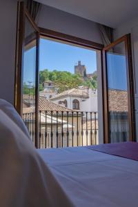 1 dormitorio con ventana y vistas a un edificio en Hotel Boutique Puerta de las Granadas en Granada