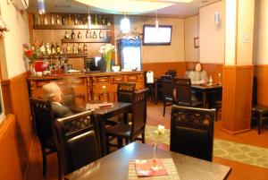 Hotel 3A في تيرانا: رجل يجلس على طاولة في مطعم