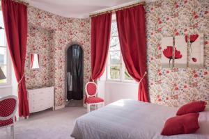 モンティニャックにあるChâteau de Puy Robert LASCAUX - Sarlatの赤いカーテンとベッド、窓が備わるベッドルーム1室が備わります。