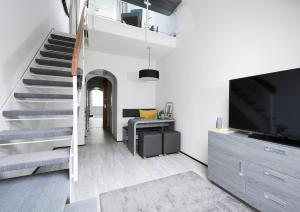 a living room with a staircase and a television at Living Hotel Kaiser Franz Joseph in Vienna