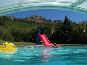 a person in a swimming pool with a water slide at Villa Paraiso. Villas Ahumada in Tarifa