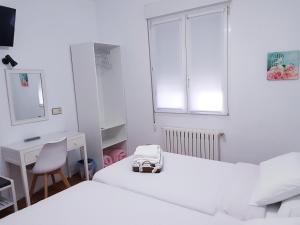 a bedroom with a white bed and white pillows at Carabela La Pinta in Baiona