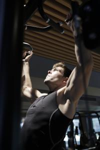 Un homme dans une salle de sport avec ses bras dans l'air dans l'établissement Crowne Plaza Bucharest, an IHG Hotel, à Bucarest