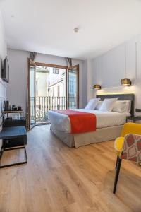 a bedroom with a large bed and a balcony at Hotel Boutique Puerta de las Granadas in Granada