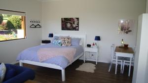 1 dormitorio con cama, escritorio y ventana en La Dolce Vita en Beechmont