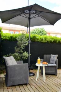 a patio with two chairs and a table with an umbrella at STUDIO'MARCEL in Blagnac