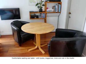 a table and two chairs in a living room at Akaroa Coastal Studio in Akaroa