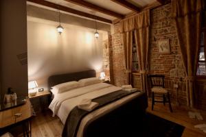a bedroom with a large bed and a brick wall at Le Petit Secret, Korce, Albania in Korçë