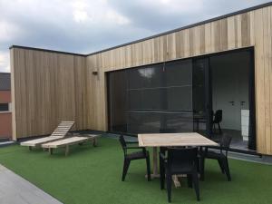 a patio with tables and chairs on a building at Gods Heide in Hasselt