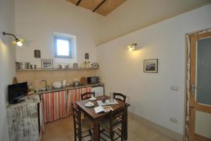 Il comprend un salon avec une table et une cuisine. dans l'établissement Palazzo San Giovanni, à Morciano di Leuca