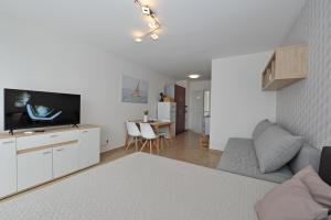 Biały salon z kanapą i telewizorem w obiekcie Bella Rosa Apartman w Balatonfüred