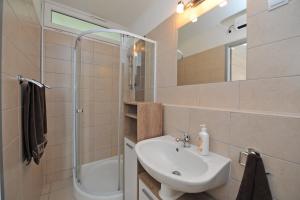 biała łazienka z umywalką i prysznicem w obiekcie Bella Rosa Apartman w Balatonfüred