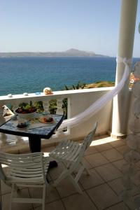 a table and chairs on a balcony with the ocean at Villa Irini in Almirida