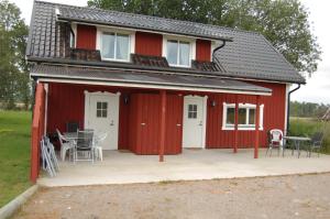 a red barn with a table and chairs in front of it at Torpa Gård in Borensberg