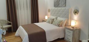 a bedroom with a bed with two lamps on a night stand at Sandra Rooms in Alicante