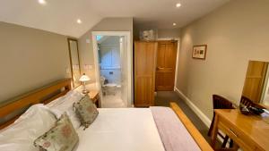 a bedroom with a bed and a desk and a bathroom at Tate House in Alnwick