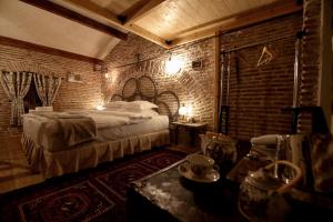 a bedroom with a bed and a brick wall at Le Petit Secret, Korce, Albania in Korçë