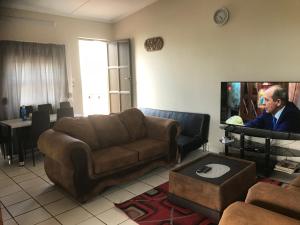 a man in a living room with a couch and a tv at Oceanic in Scottburgh