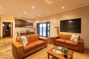 a living room with two couches and a table at Steenbok farm cottages -Mongoose cottage in Wolseley