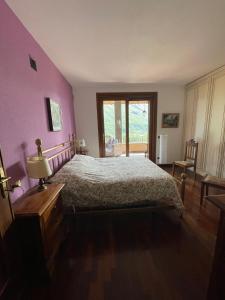 - une chambre avec un grand lit aux murs violets dans l'établissement B&B Gli Ulivi, à Carlazzo