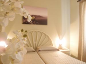 um quarto com uma cama com flores brancas em Hotel Corallo em Lipari