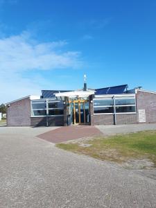 a brick building with a cross on top of it at Caravan Petiet in Buren