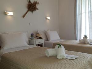 ein Hotelzimmer mit zwei Betten mit Handtüchern darauf in der Unterkunft Corfu Olivia Apartments in Moraḯtika