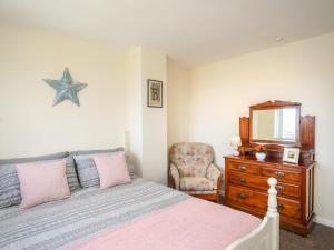 a bedroom with a bed and a mirror and a chair at Yr Hafan in Colwyn Bay