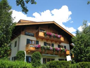 a building with a balcony with flowers on it at Feriennest Leitner in Maria Alm am Steinernen Meer