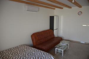 1 dormitorio con sofá marrón y mesa en studio apartman Kata, en Prvić Šepurine