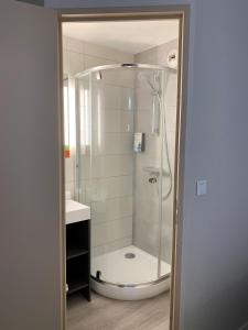 a shower in a bathroom with a glass shower at initial by balladins Tours Sud in Chambray-lès-Tours