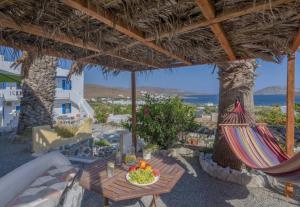 MaltezanaPoseidon Studios的一个带桌子和吊床的庭院,享有海景。